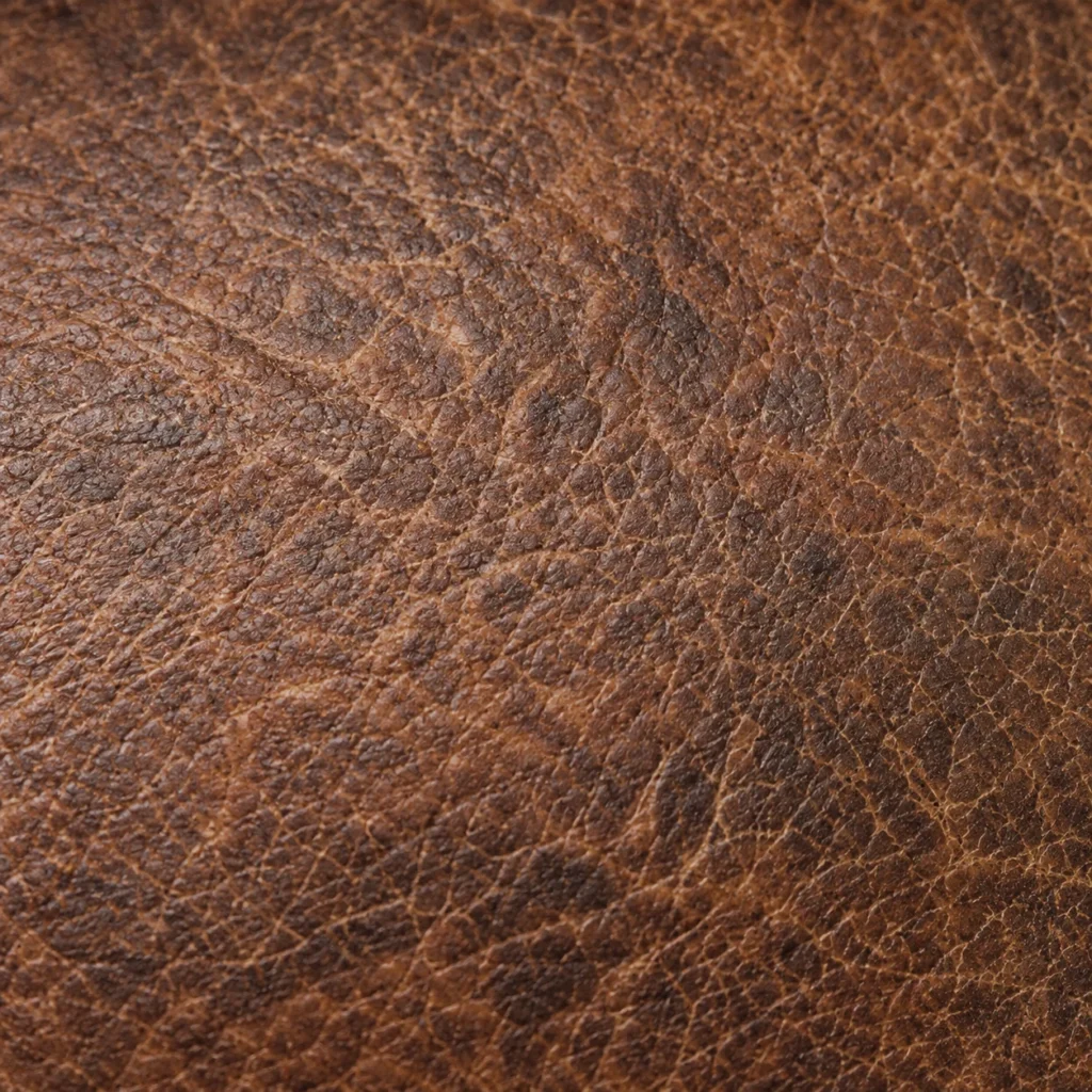 Close view of aged brown leather grain with natural patina