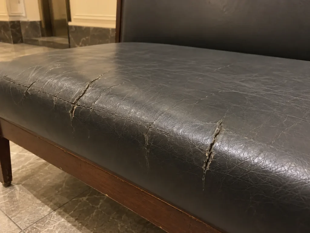 A common-area bench with a cracked vinyl seat