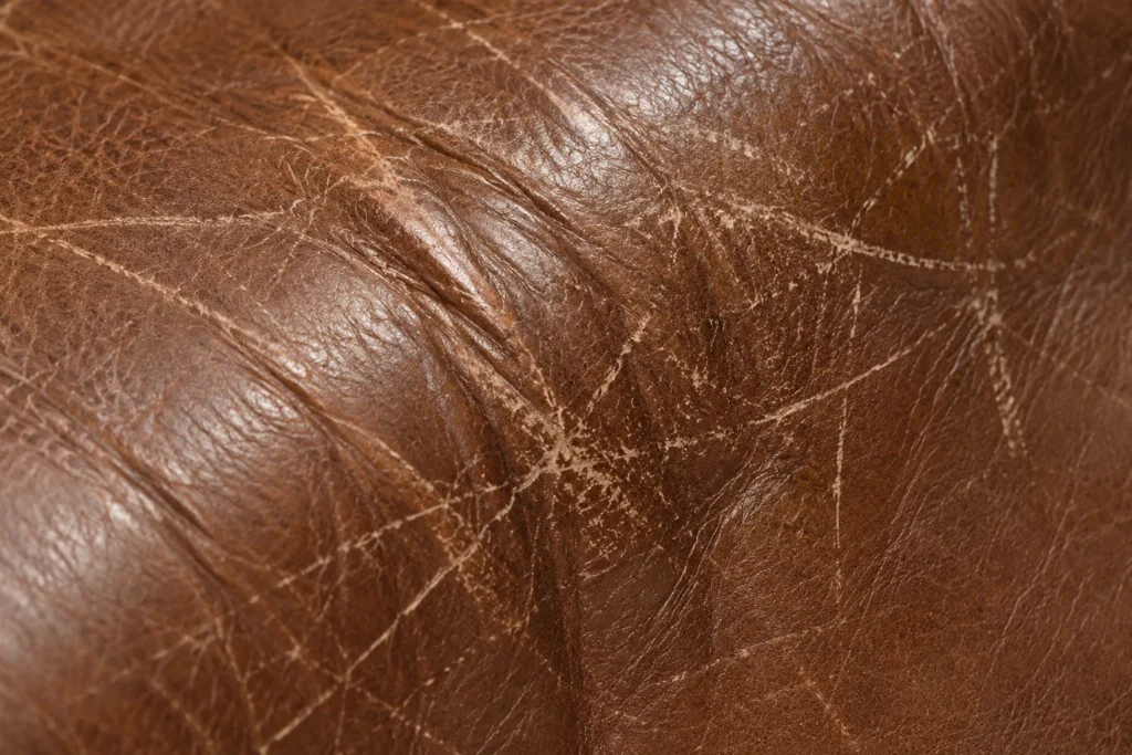 Creased, scuffed leather detail on a sleeper sofa